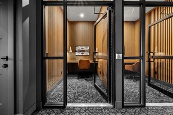 A room with a black door and a wooden wall.